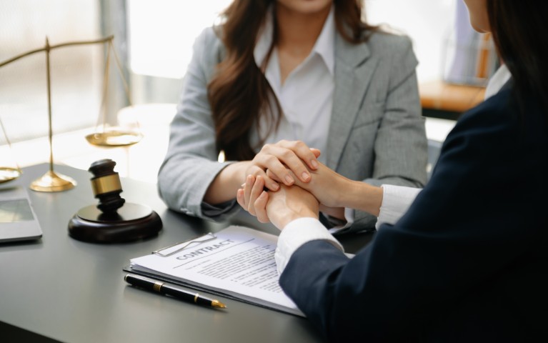 A lawyer comforting a client in a consultation